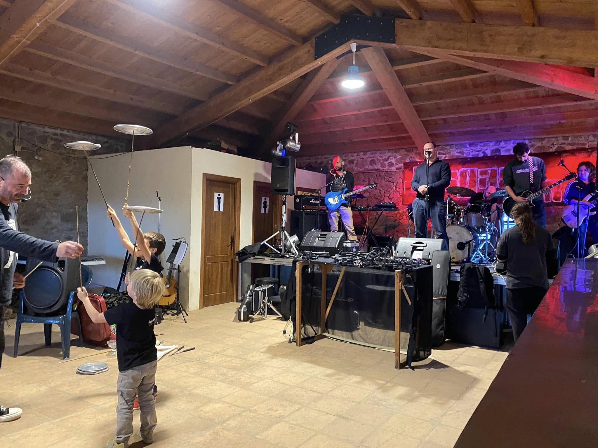 Banda tocando en el interior con niños delante en 2024